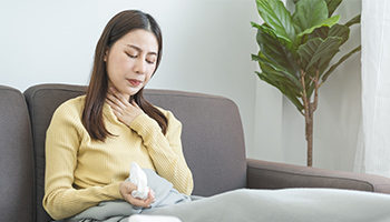 Frau mit Halsschmerzen auf einer Seite