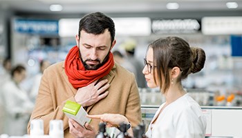 Mann kauft erkältet Medikamente in einer Apotheke