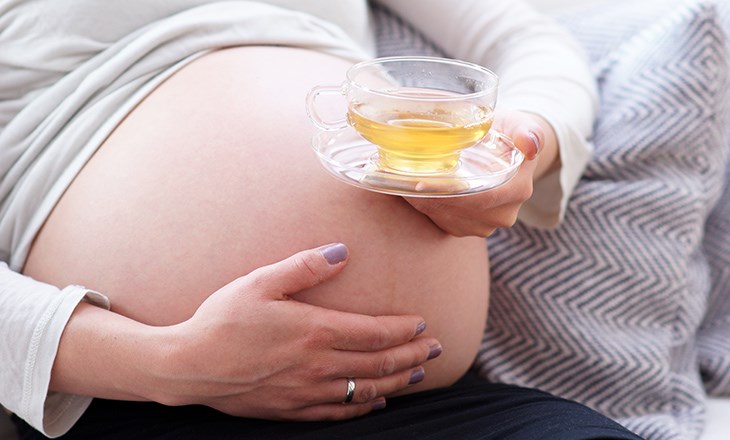 Eine schwangere Frau trinkt Tee