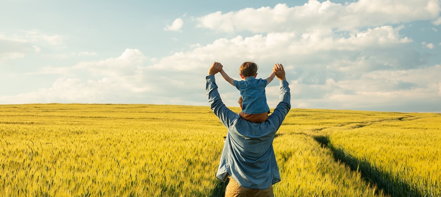 Vater und Kind stehen in einem Weizenfeld