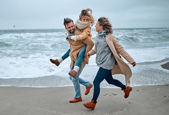 Eine Familie geht am Strand spazieren 