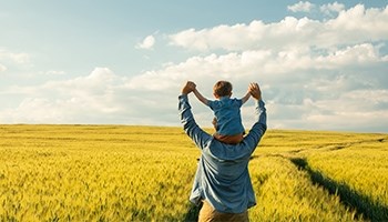 Vater und Kind stehen in einem Weizenfeld