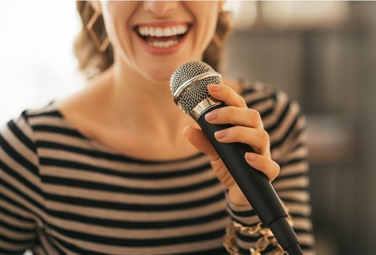 Eine Frau singt in ein Mikrofon